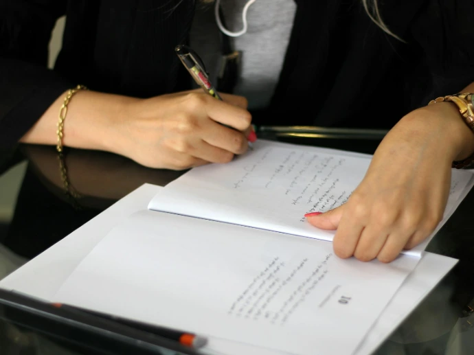 a person writing on a piece of paper